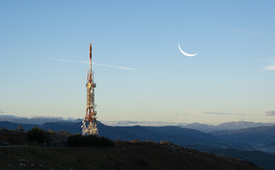 telecommunications tower with the moon at dawn