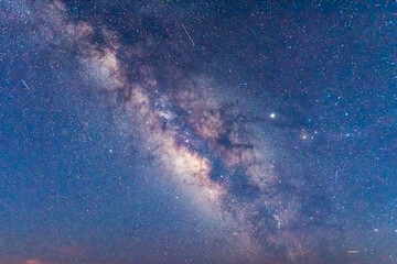 Night sky skyscape with many stars in milky way in Bryce Canyon National Park in Utah at Pariah view overlook looking up with colorful blue and yellow colors