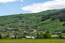 Mount Crested Butte Village Town Houses In Summer With Many Wooden Lodging Buildings On Hillside With Green Lush Color Grass