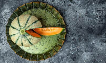 Wall Mural - cantaloupe melon. whole and slice of japanese melons, orange melon with seeds on dark background. place for text, top view