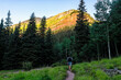 © Kristina Blokhin - Man hiker walking on green alpine footpath trail to Ice lake near Silverton, Colorado in August early summer morning at sunrise with sunlight on peak