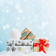 Wall Mural - Christmas gift boxes against light blue bokeh background. Holiday greeting card with copy space.