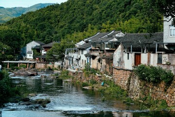 Scenery of old small buildings on the shore of the river in the mountains