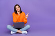 © deagreez - Full body photo of pretty young lady working laptop point empty space wear trendy knitwear orange look isolated on violet color background