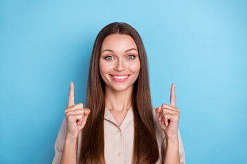 Wall Mural - Photo of adorable girlish gorgeous woman with straight hairstyle wear beige shirt indicating empty space isolated on blue color background