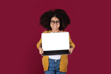 Wall Mural - Cheerful black child holding laptop with white screen, mockup