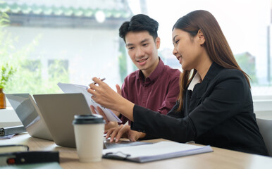 Two young business people discussing startup project while working together at co working office.