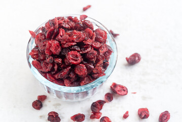Wall Mural - dried organic cranberry in glass bowl on white table background.