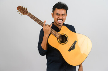 Wall Mural - Portrait of Young Asian man playing an acoustic guitar isolated on white background