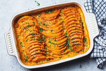 Wall Mural - Roasted sweet potato gratin with parsley in ceramic pan. Vegan healthy recipe concept.