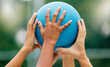 © Talia M/peopleimages.com - Netball, hands and woman holding a ball during a game for support, teamwork or training together. Sports, community and collaboration for a team of athlete people at a sport event with solidarity