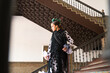 Beautiful teenage woman dancing flamenco with white dress and black polka dots doing flamenco postures on a staircase. She wears a black shawl with fringes. Flamenco cultural heritage of humanity.