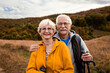 © Zoran Zeremski - Portrait of active senior couple with backpacks hiking together in nature on autumn day.