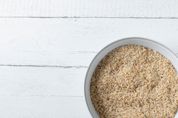 Wall Mural - Raw and uncooked brown rice on white background