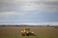 Old Yellow Tractor Running In The Field