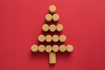 Wall Mural - Christmas tree made of wine corks on red background, top view