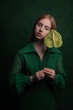 © Milou Dirks - classic painterly studio portrait of a woman in green dress holding leaf