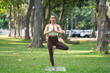 © Songsak C - Asian slim woman exercise alone in the park, Tired from a workout, Play yoga concept