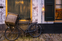 Enkhuizen, Netherlands. October 2022. Old Cargo Bike And Oil Lamp Against A Wall.