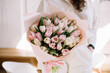 Very nice young woman holding beautiful bouquet of fresh pink and white tulip flowers, cropped photo, bouquet close up