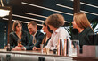 © standret - Sitting by the bar table. Group of people in beautiful elegant clothes are celebrating New Year indoors together