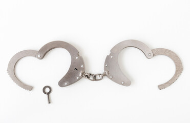 handcuffs with a key in the form of a heart, on a white isolated background