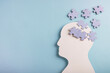Head silhouette with puzzles inside on pastel blue background. Mental health concept, Alzheimer disease, memory loss or dementia. Top view, copy space