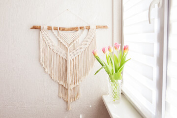 Wall Mural - Handmade macrame wallhanging. 100% cotton wall decoration with wooden stick hanging on a white wall.    Female hobby.  ECO friendly modern concept in the interior.