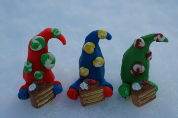 Wall Mural - Three fabulous dwarfs with treats on a background of snow.