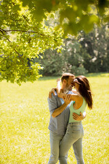 Wall Mural - Happy young couple in love at the grass field