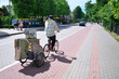 The artist moves with his paintings. A man rides a bicycle with a trailer. Street artist. Selective focus.