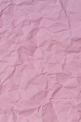 Wall Mural - Pastel pink crumpled wrinkled paper texture background. Abstract pink color vertical background