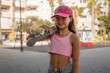 little cute girl with skateboard and cap. photo of cute child girl with skateboard outdoors
