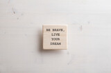 Fototapeta Kawa jest smaczna - Wooden tile with a Be brave live your dream sign written on it