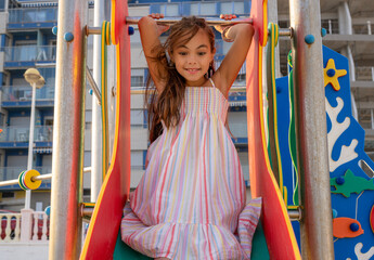 Wall Mural - Little cute child girl in playground on the beach with smile on summer vacation. Happy children kid enjoy and fun outdoor activity lifestyle