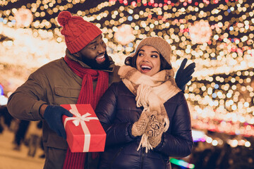 Wall Mural - Portrait of attractive cheerful couple friends sharing giving handling giftbox having fun greetings congrats city urban outdoors