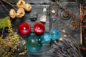 Wall Mural - Old magic book and dry natural herbs and remedy bottle on the wooden table flat lay background.