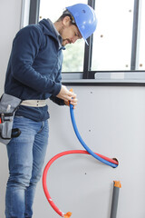 plumber man installing water pipe in new built house