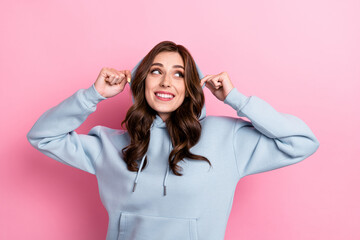 Photo of pretty cheerful lady hands touch hood look interested empty space isolated on pink color background