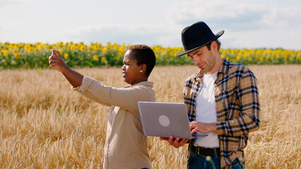 Poster - Family business two farmers lady and man in the middle of wheat field discussing about the ears of wheat and take some notes on the laptop to make a analysing