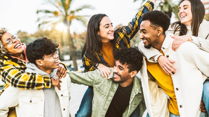 Wall Mural - Multiethnic friends having fun walking in the city street on vacation - Cheerful millennial people laughing out loud together outside - Youth and friendship concept