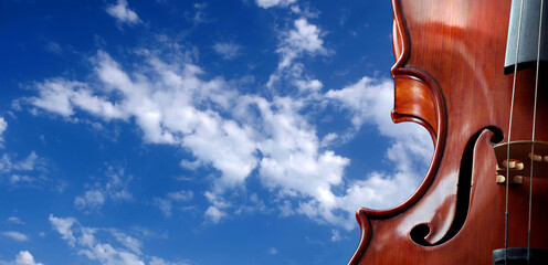 Wall Mural - A beautiful violin against a blue sky with clouds. Melody concept. copy spaces.