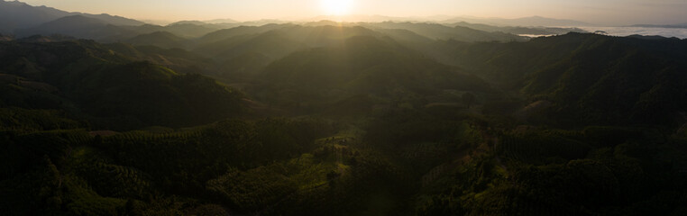 Wall Mural - panoramic landscape of mountains layer and forests. The sun rays are shining through the fog. The play of light and shadows. dramatic natural scenery north of thailand. aerial view