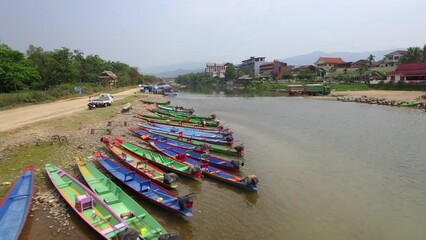 Wall Mural - Aerial view of colourful boats on the bank of the Nam Song river in Vang Vieng, a small town north of Vientiane in Laos.	
