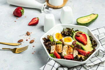 Poster - Ketogenic low carbs diet, Plate with keto foods: two eggs, avocado, grilled chicken fillet, nuts, strawberries and fresh salad. Healthy fats, clean eating for weight loss. top view