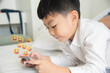 © ic36006 - Asian kids enjoy using their smartphones to play games and watch cartoons in the bedroom. Technology concept.