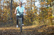 © bogdan vacarciuc - The man relaxes by taking a bike ride through the forest. Bike tour in an autumn setting.