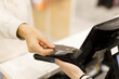 © Александра Алероева - Hands hold a credit card and pay for purchases in the store. Credit card in hand, hands, point of sale, purchases in the store. A woman buys goods in a supermarket.