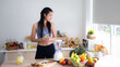 © chokniti - Fit and healthy young Asian woman in sportswear preparing and drinking fresh lemon water for healthy lifestyle and fitness in modern kitchen after morning workout and exercise
