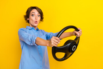 Poster - Photo of adorable shocked lady wear blue shirt driving car empty space isolated yellow color background